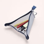 A triangular mesh pencil pouch with a navy blue zipper and trim, shown open with pens and a sticky note inside, on a light beige background.