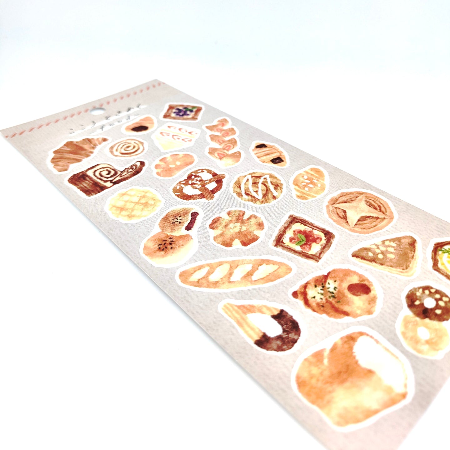 Sheet of bread-themed stickers with khaki back card placed on a white background.