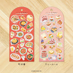 Chinese food-theme sticker sheet on red back card, and Cake-theme sticker sheet on a pink back card, placed on wooden texture background.