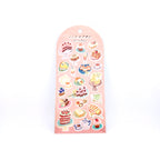 Sheet of cake-themed stickers on a pink back card, placed on white background.