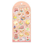 Sheet of cake-themed stickers on a pink back card, placed on white background.