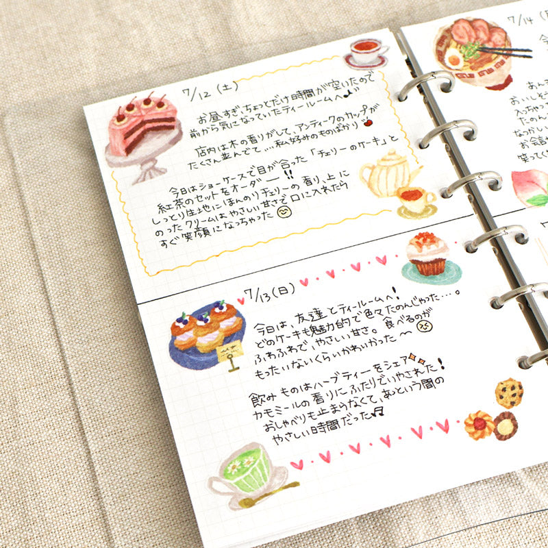 A diary written with Japanese applied with different cake and tea stickers.
