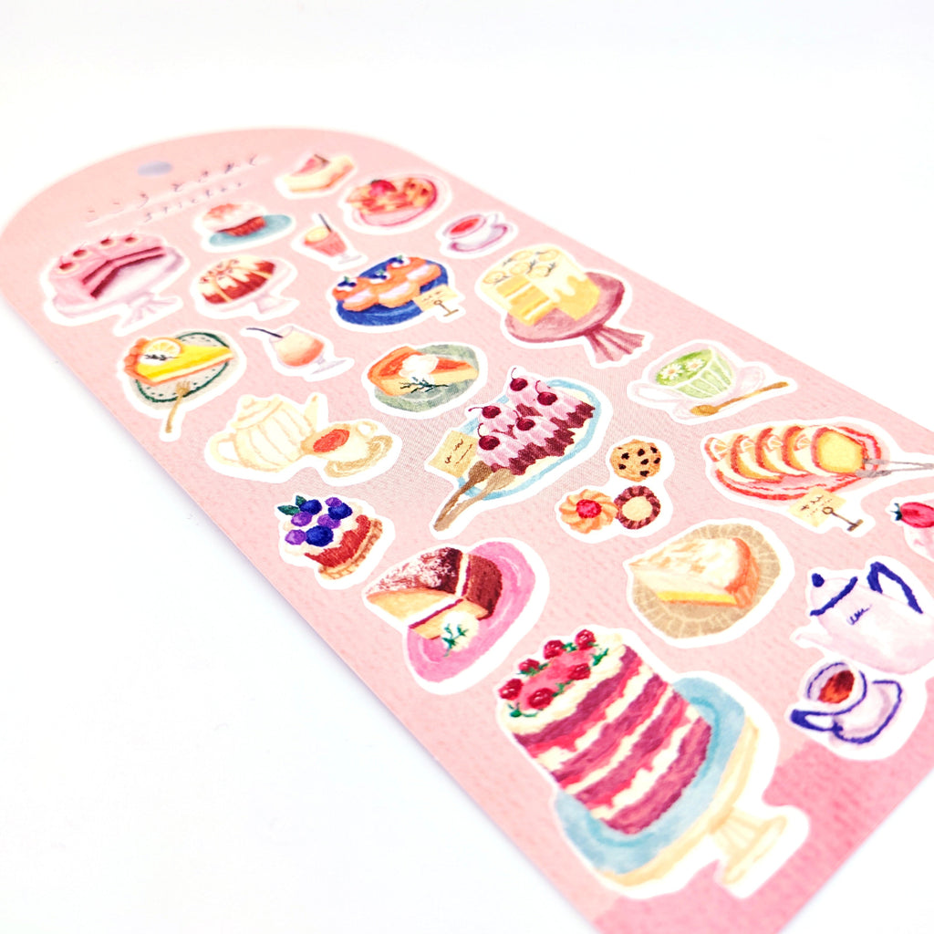 Sheet of cake-themed stickers on a pink back card, placed on white background.