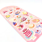 Sheet of cake-themed stickers on a pink back card, placed on white background.