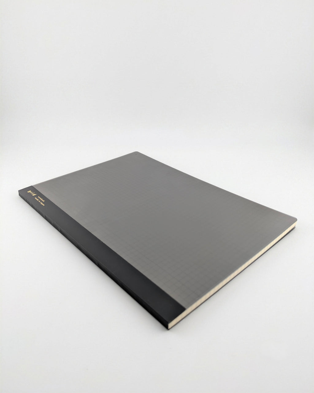 A hardcover notebook or journal with a textured dark gray cover and a black spine, photographed at an angle on a light gray background.