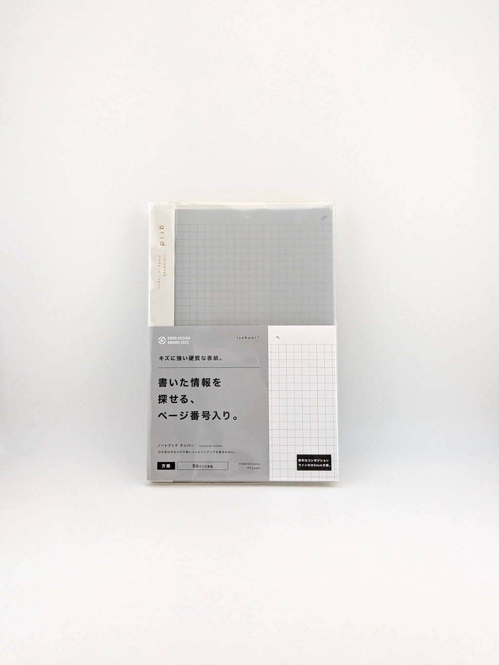 A packaged notebook with a light gray grid cover and a white label section featuring Japanese text, photographed against a plain white background.