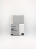 A packaged notebook with a light gray grid cover and a white label section featuring Japanese text, photographed against a plain white background.