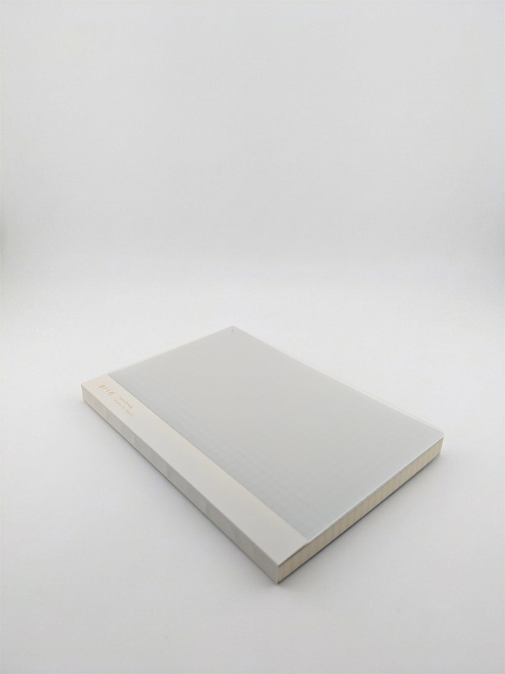 A minimalist hardcover book or notebook with a light gray cover and a beige spine, photographed on a seamless light gray studio background.