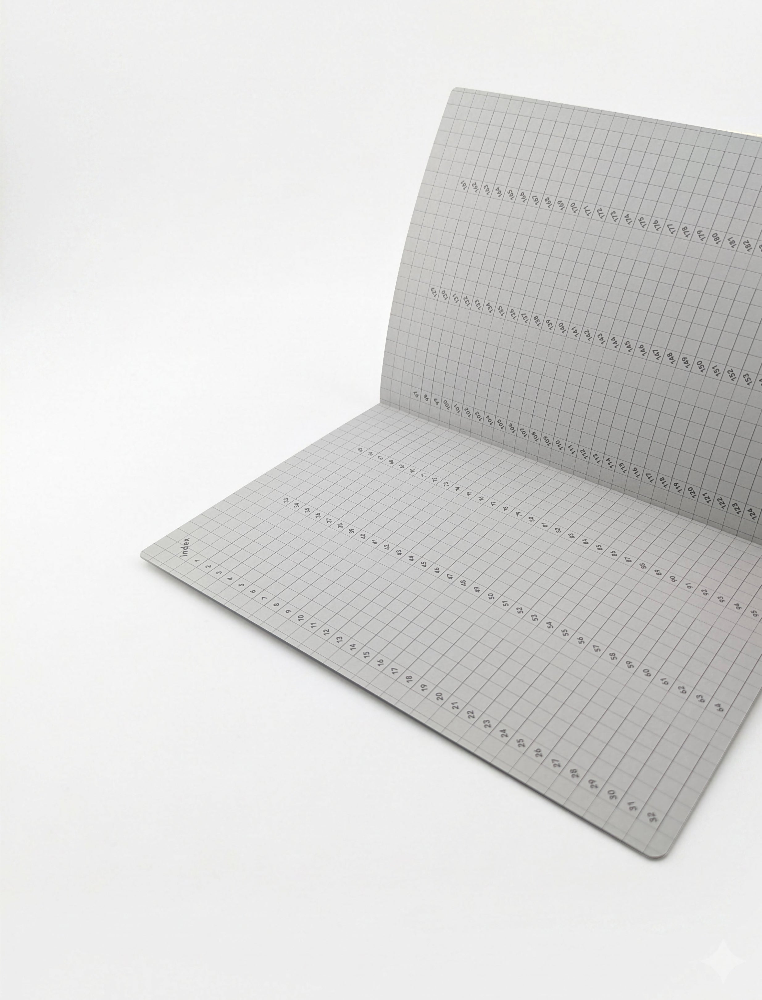 A gray grid cutting mat with printed measurement markings, shown partially unfolded on a clean white background.