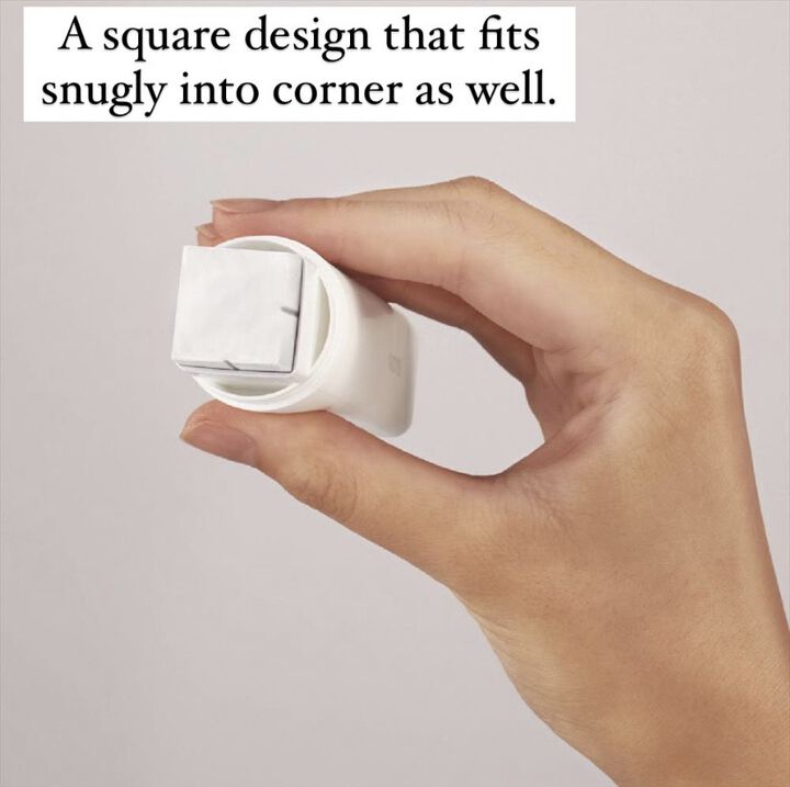 Hand holding square glue stick on light grey background.