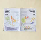 Opened book with pot image and ingredients on both pages, set against light yellow background.
