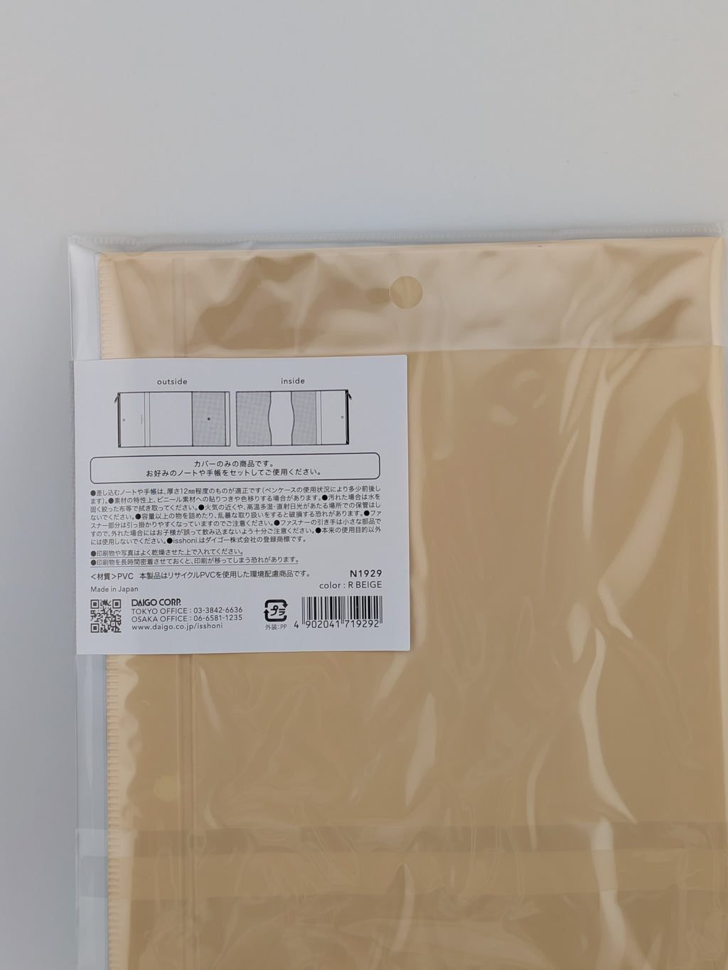 A packaged beige fabric panel or sheet with a white product label showing a simple diagram and Japanese text, photographed against a plain light background.