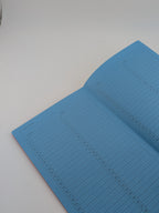 An open notebook with light blue lined pages on a plain white surface.