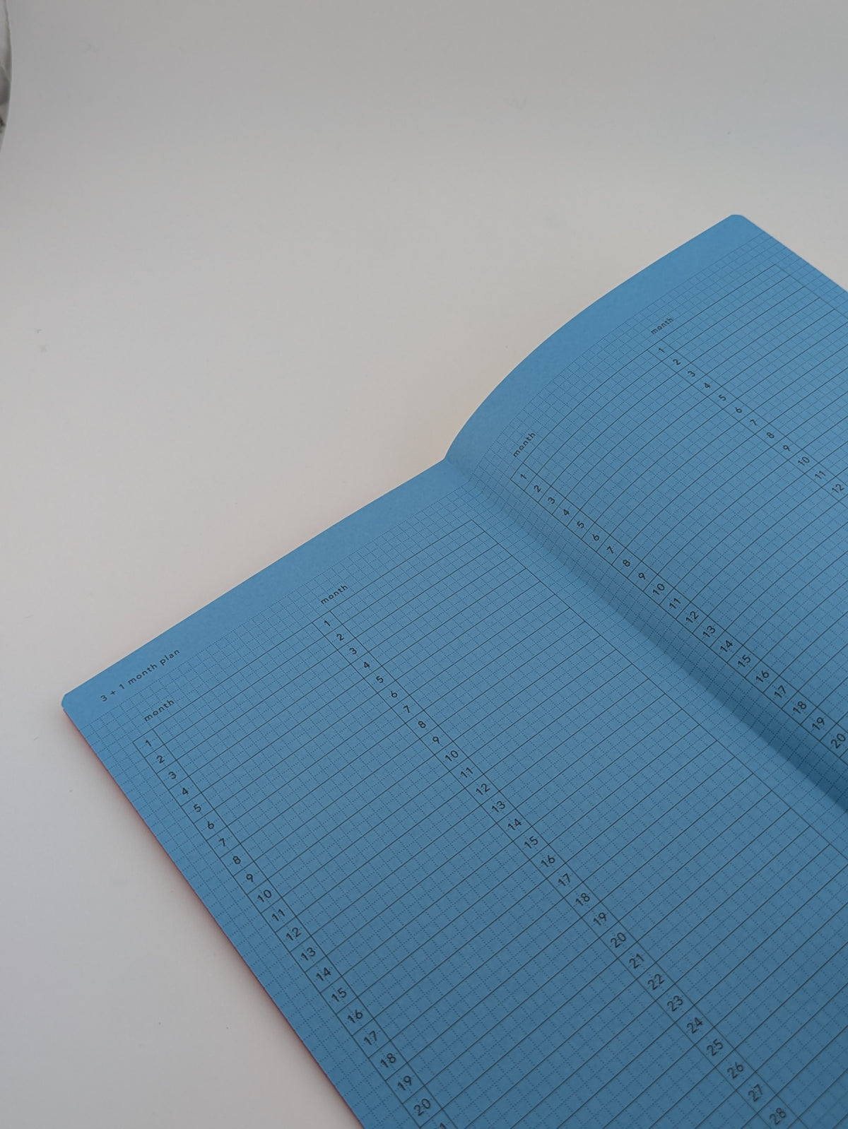 An open notebook with light blue lined pages on a plain white surface.