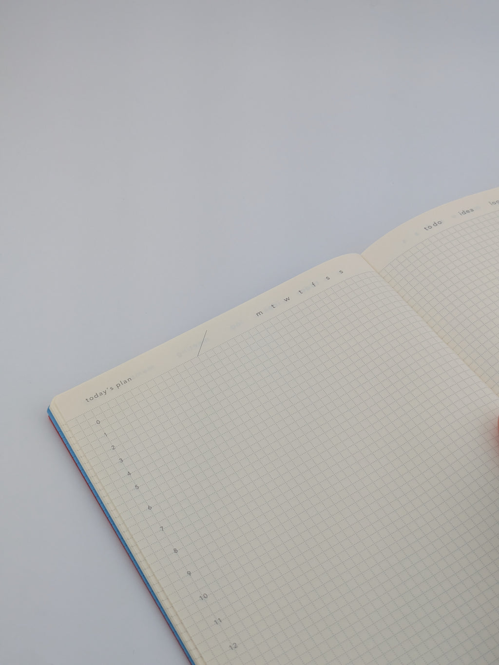 An open grid planner with cream white page for day planning, indicating with time on the left.
