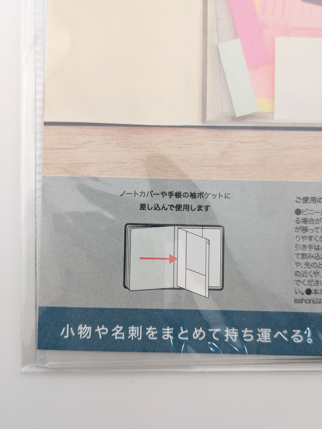 A close-up of a Japanese instruction sheet for a notebook or pocket folder organizer, showing a simple diagram of the product with an arrow indicating how to insert items, alongside Japanese text instructions.