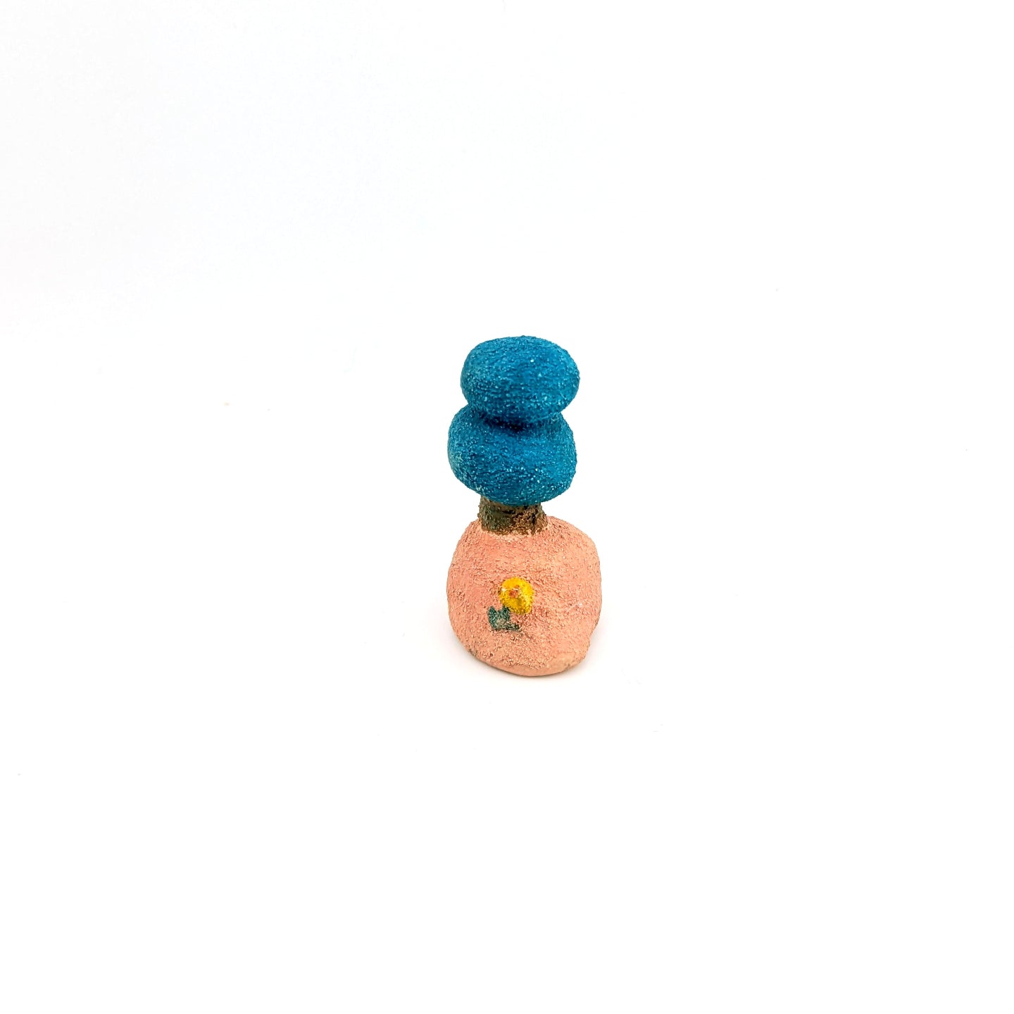 Small pink and blue tree-shaped ring holder on white background.