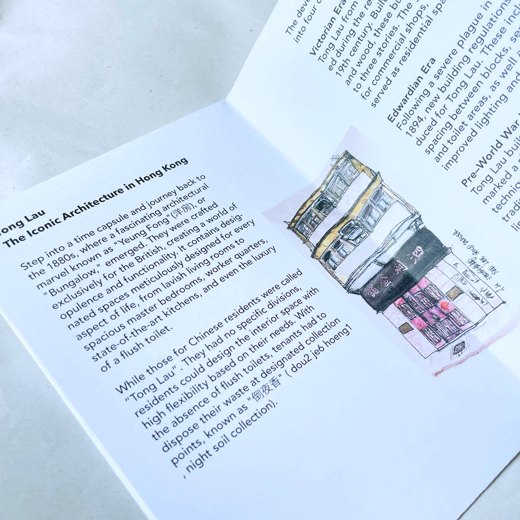 Open book with text and illustration of a building on a white surface.