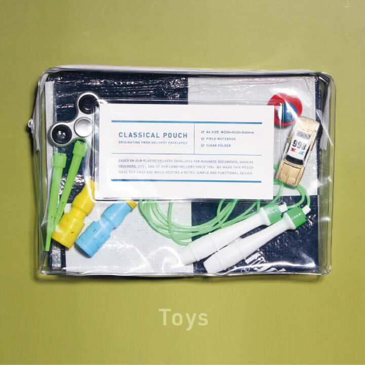 Transparent case with zipper packed with toys on green background