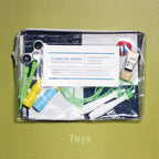 Transparent case with zipper packed with toys on green background