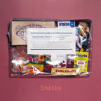 Transparent case with zipper packed with snacks on red background.