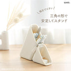 Triangular white stand with stationery items on a wooden surface, featuring the brand 'SONIC'.